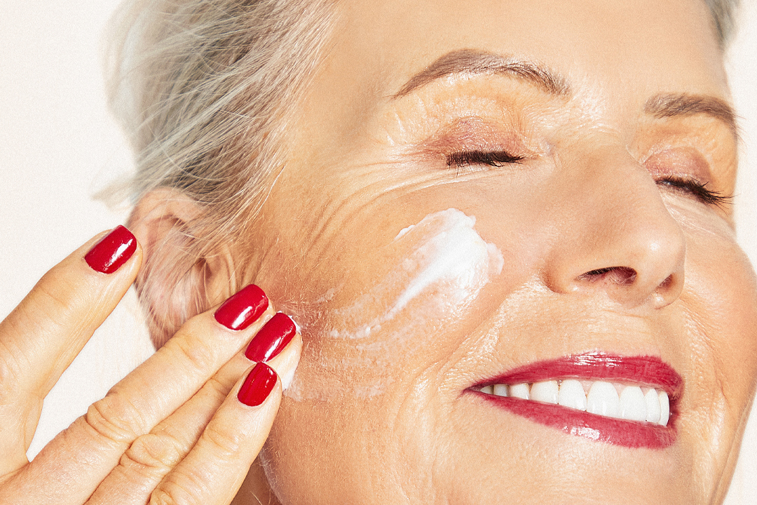 Women applying skincare on face smiling