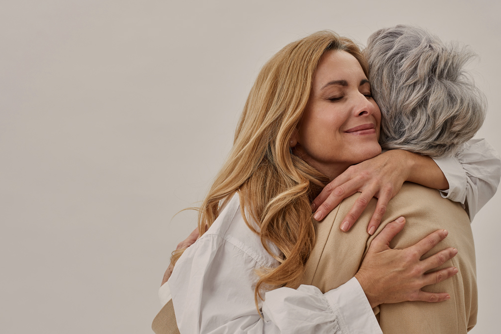 Mother and daughter holding each other in embrace, hugging