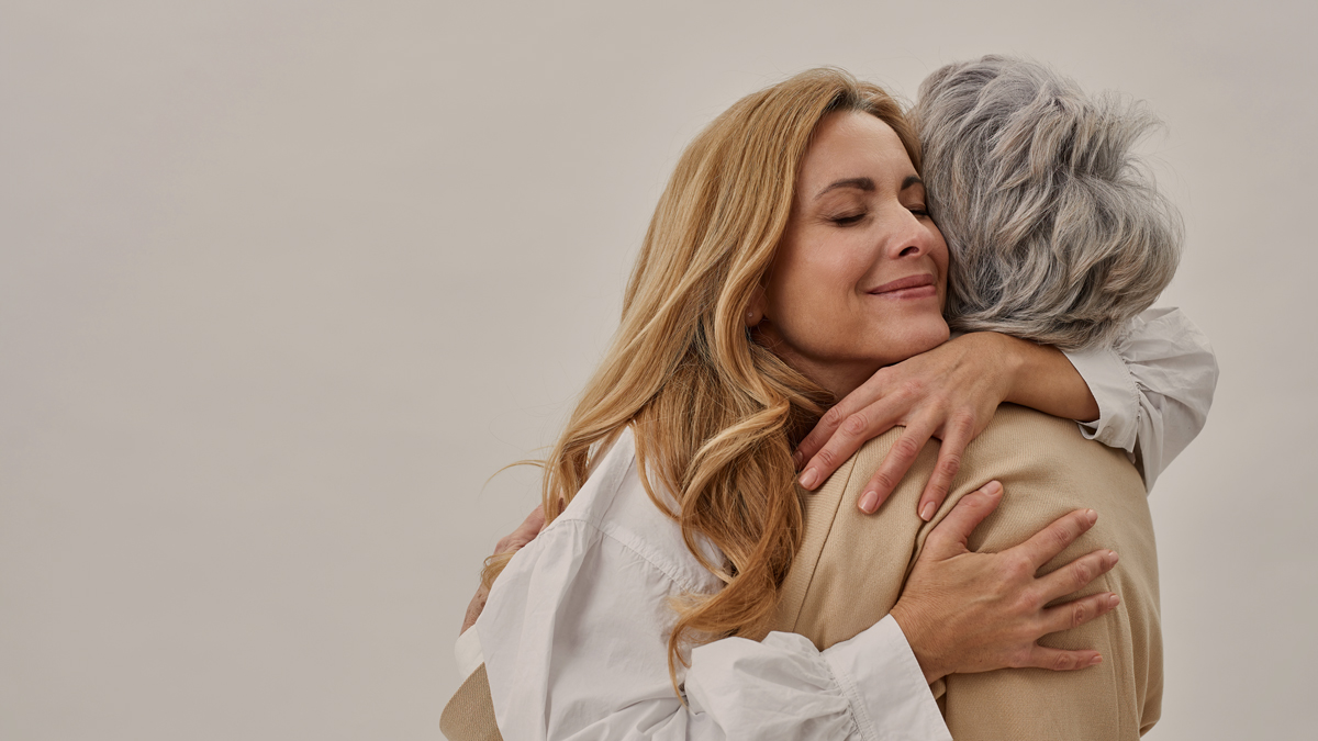 Mother and daughter holding each other in embrace, hugging
