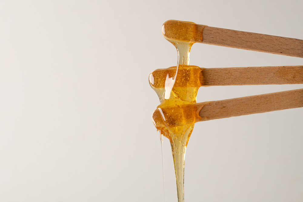 Hot wax dripping off wooden sticks