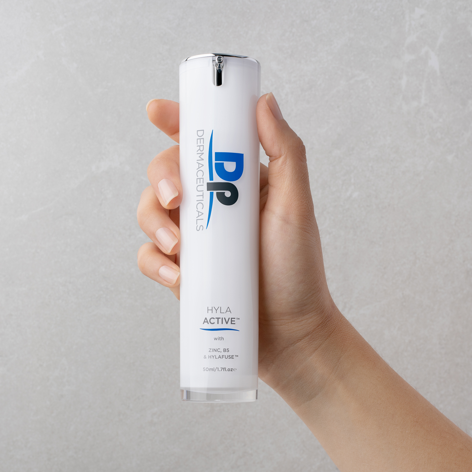 Hand holding Dp Dermaceuticals Hyla Active 50ml bottle in front of grey backdrop