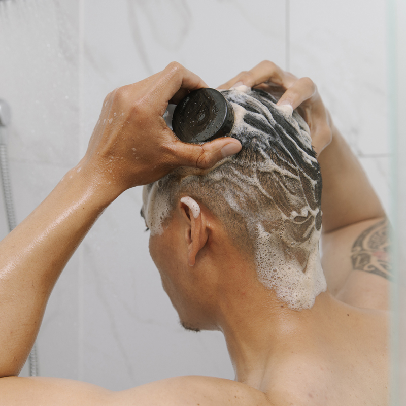 Man applying Dp Dermaceuticals Colour Recharge Shampoo Bar on hair