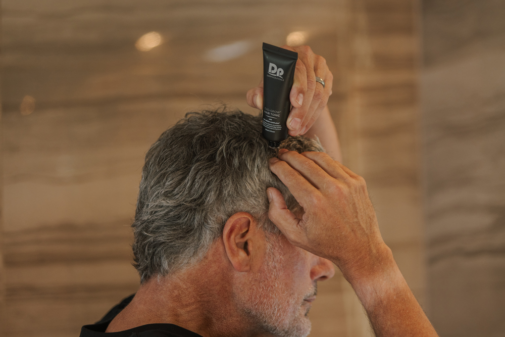 Male applying Dp Dermaceuticals Exo-Grow to hair and scalp
