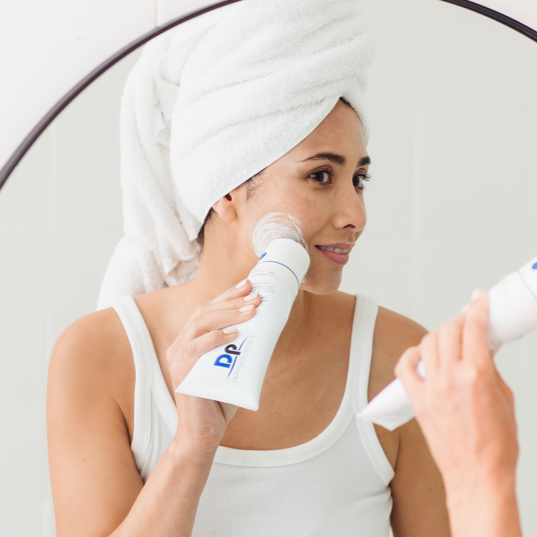 Lady using Dp Dermaceuticals OsciSonic Cleanser head on face