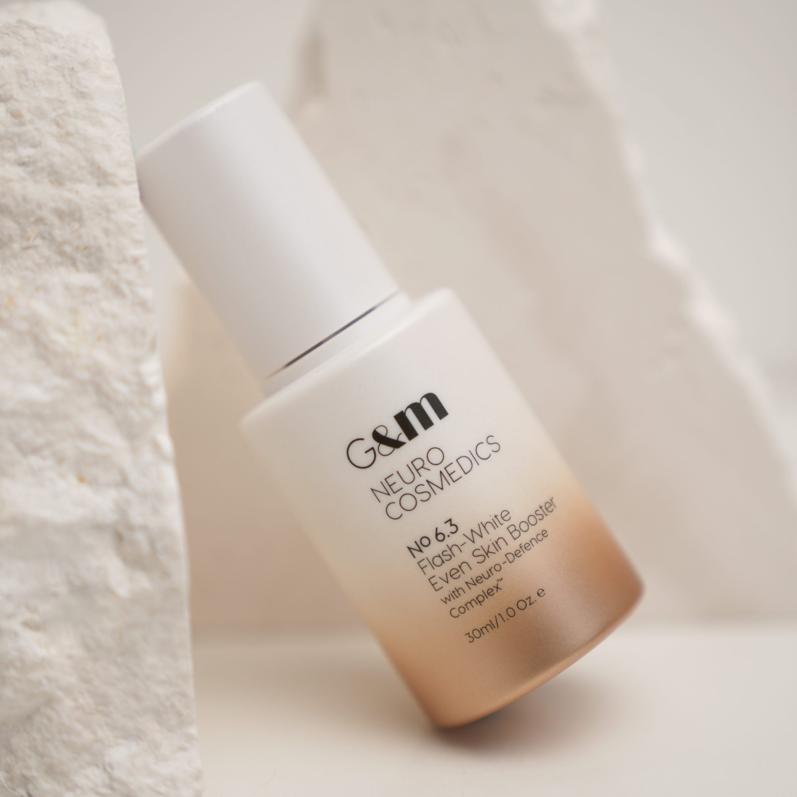 NEURO Flash-White Even Skin Booster leaning against stone