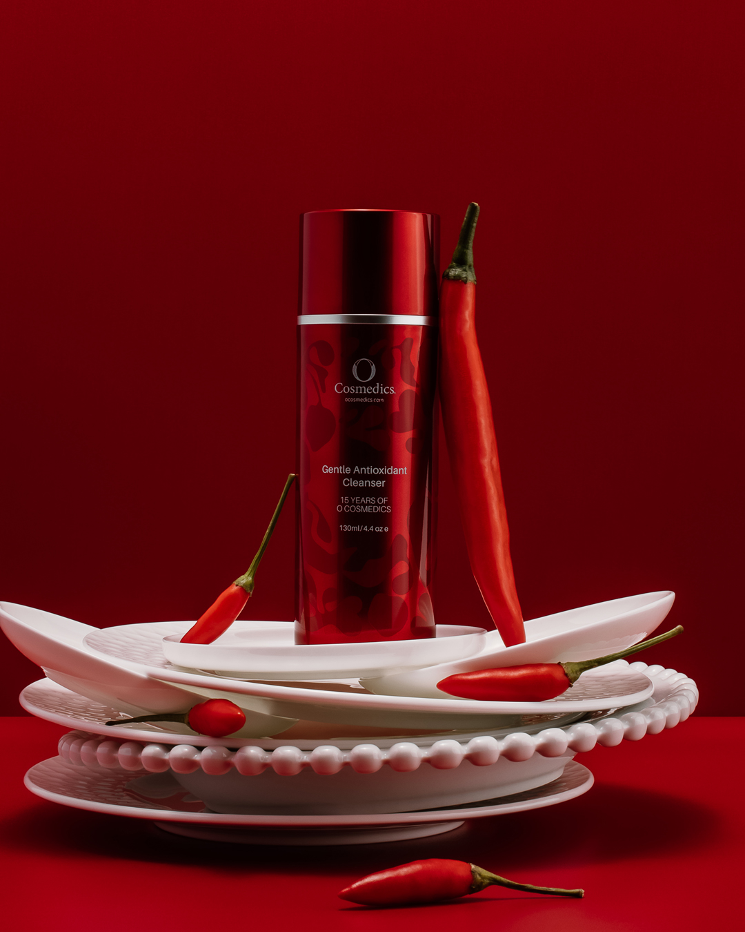 O COSMEDICS Gentle Antioxidant Cleanser limited edition on plate, with chilis and red background