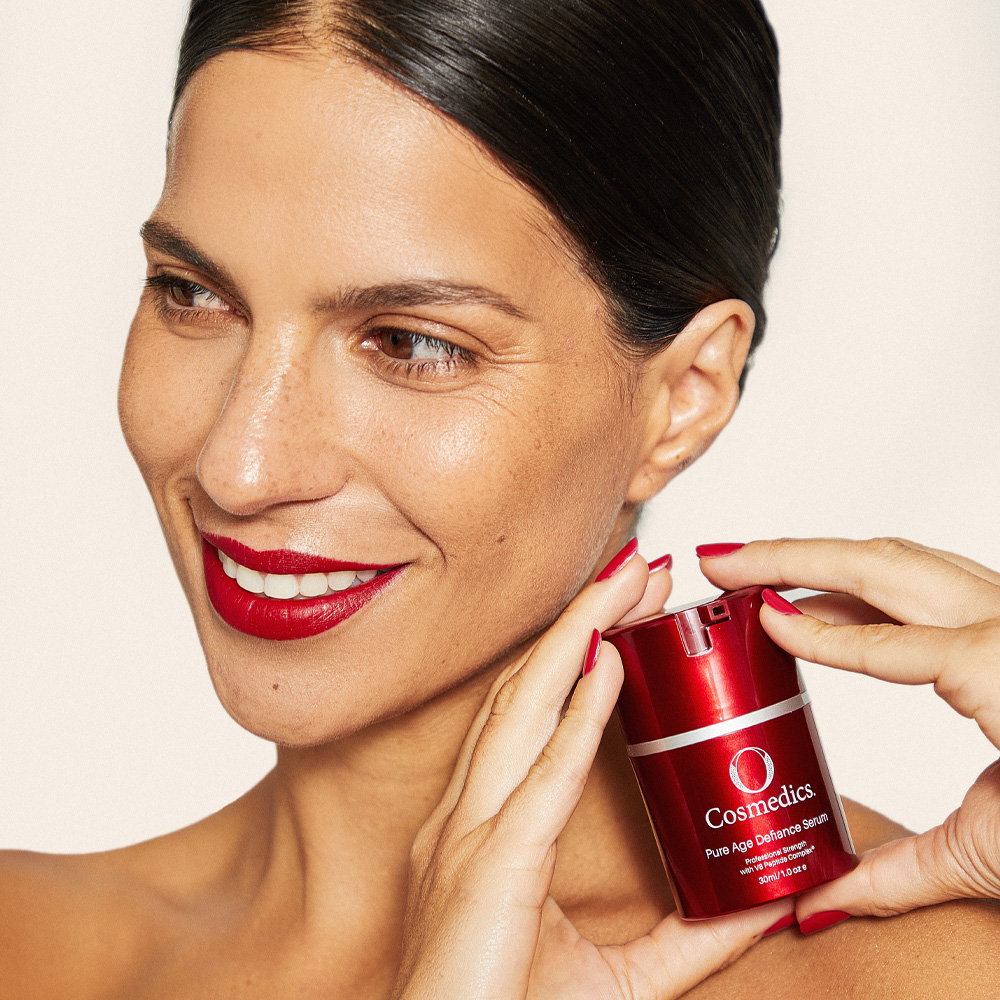 Lady holding O COSMEDICS Pure Age Defiance Serum by shoulder