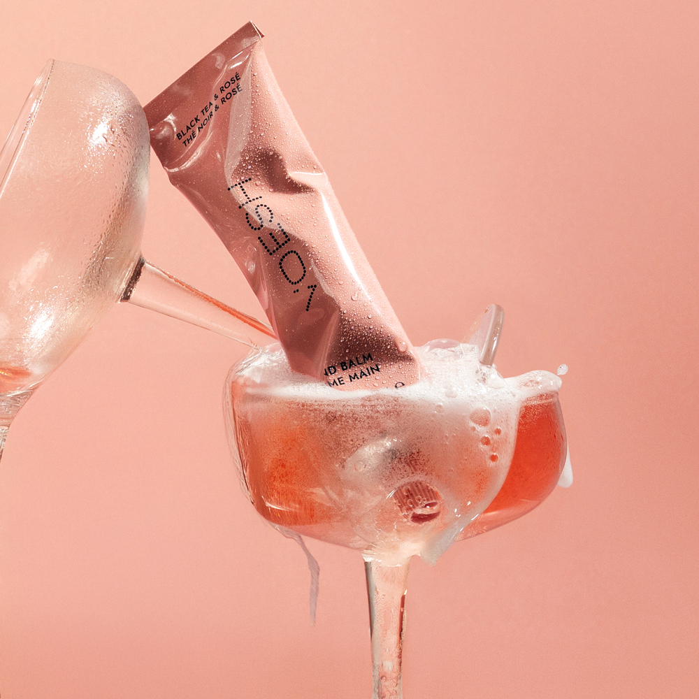 VOESH Hand Balm Black Tea & Rosé in champange glass with orange liquid