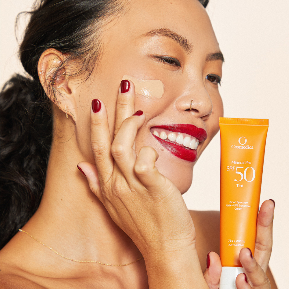 woman applying o cosmedics mineral pro SPF 50 on her cheek